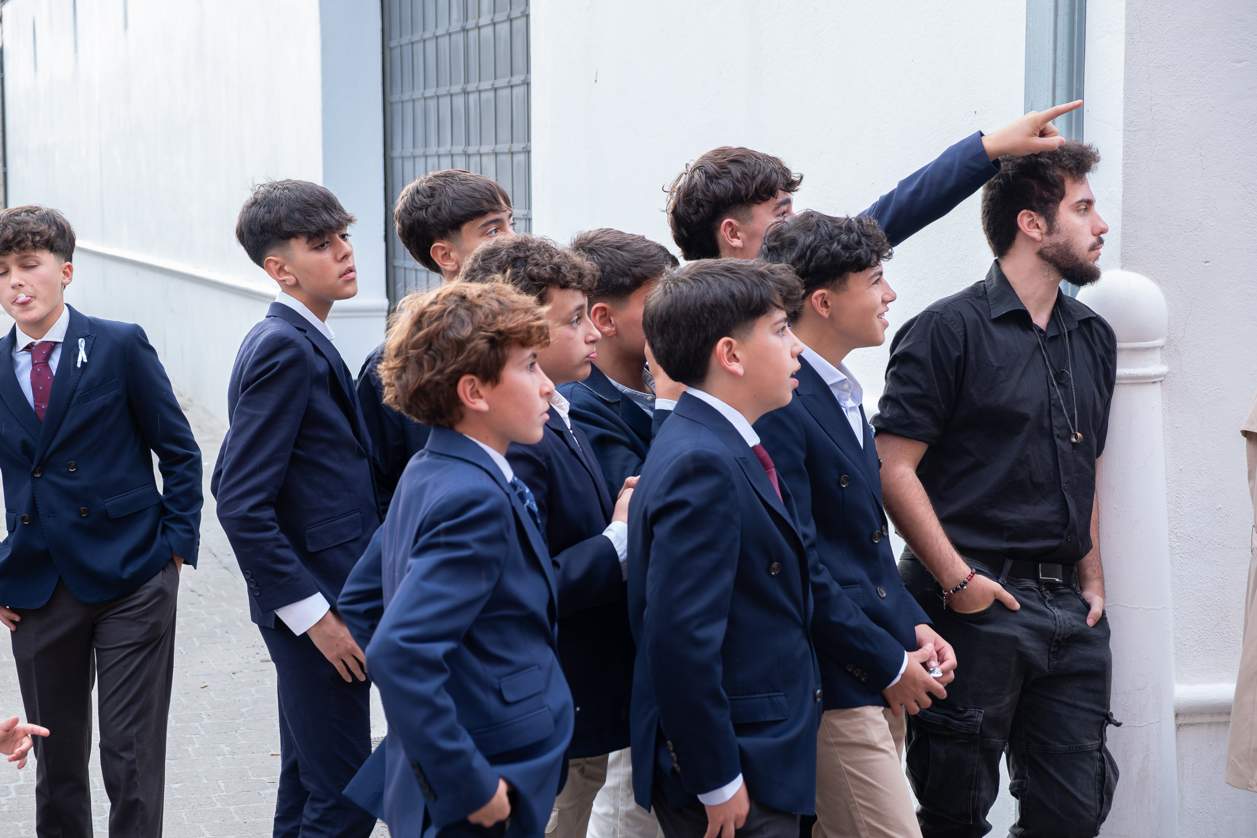 Jugendliche in Anzügen beobachten die Prozession